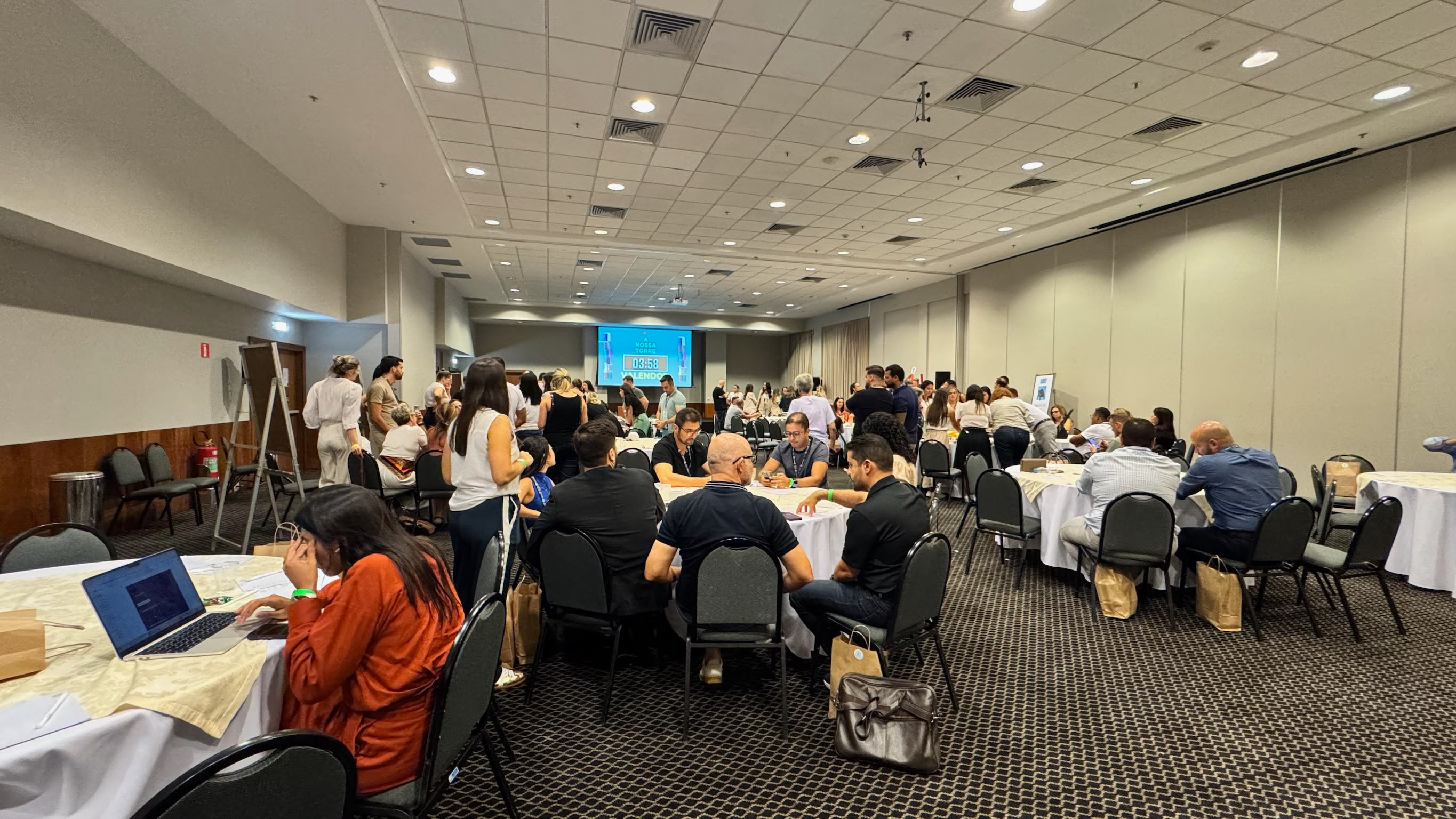 Grande convenção corporativa com participantes reunidos em equipes